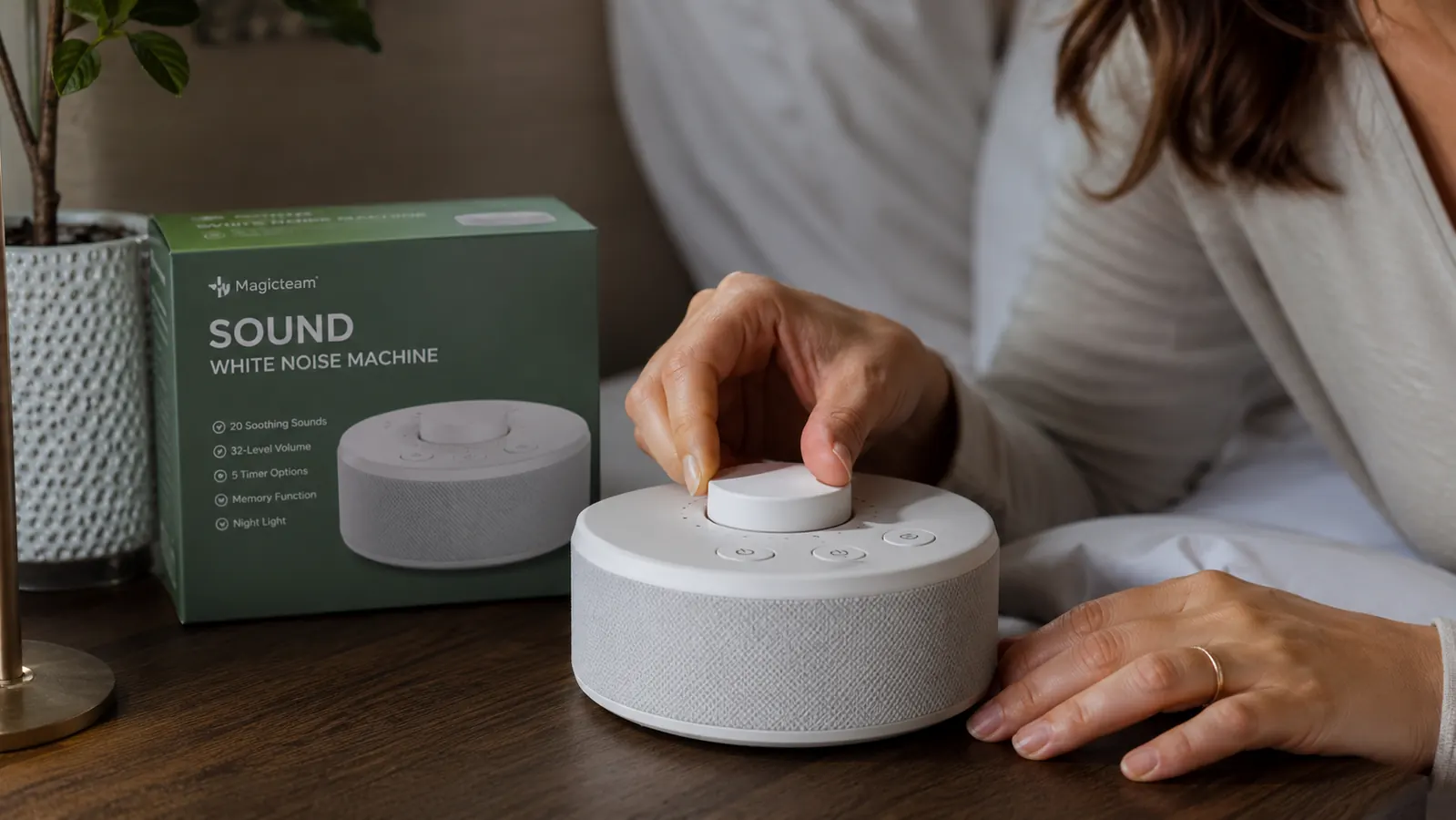 Hand testing the stepped volume dial on the Magicteam white noise machine, showing the lack of numbered markings